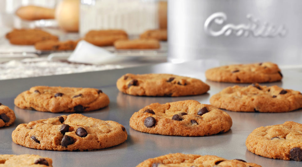 fresh baked chocolate chip cookies on a cookie sheet