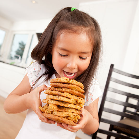 small child with a stack of giant cookies